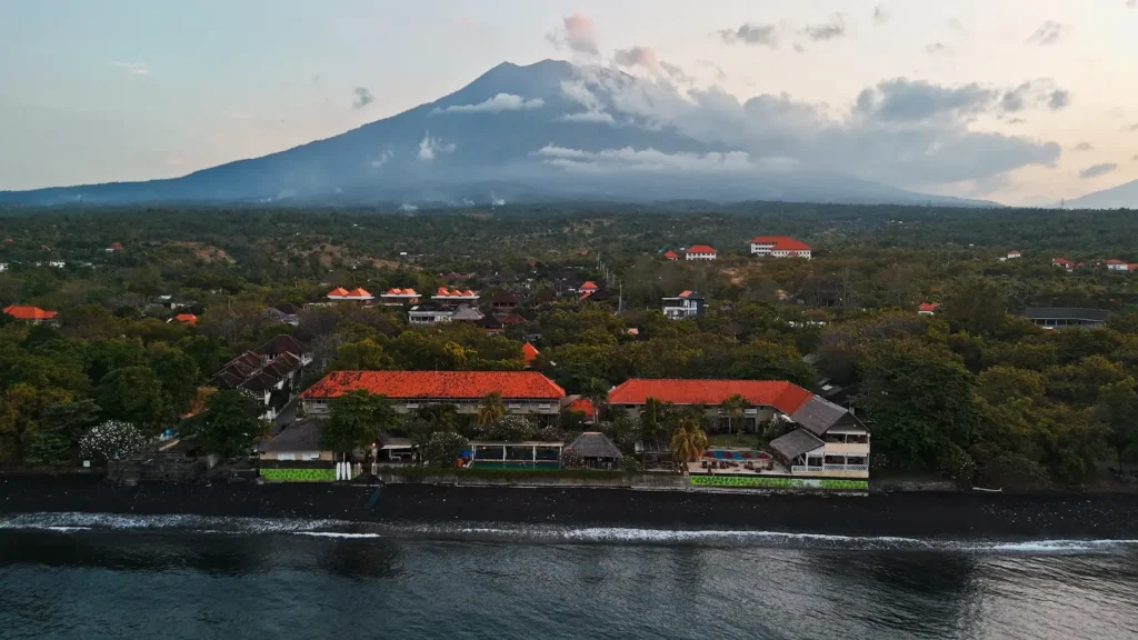Drone shot of Mount Agung overlooking the coastline and dive resorts of Tulamben, Bali.