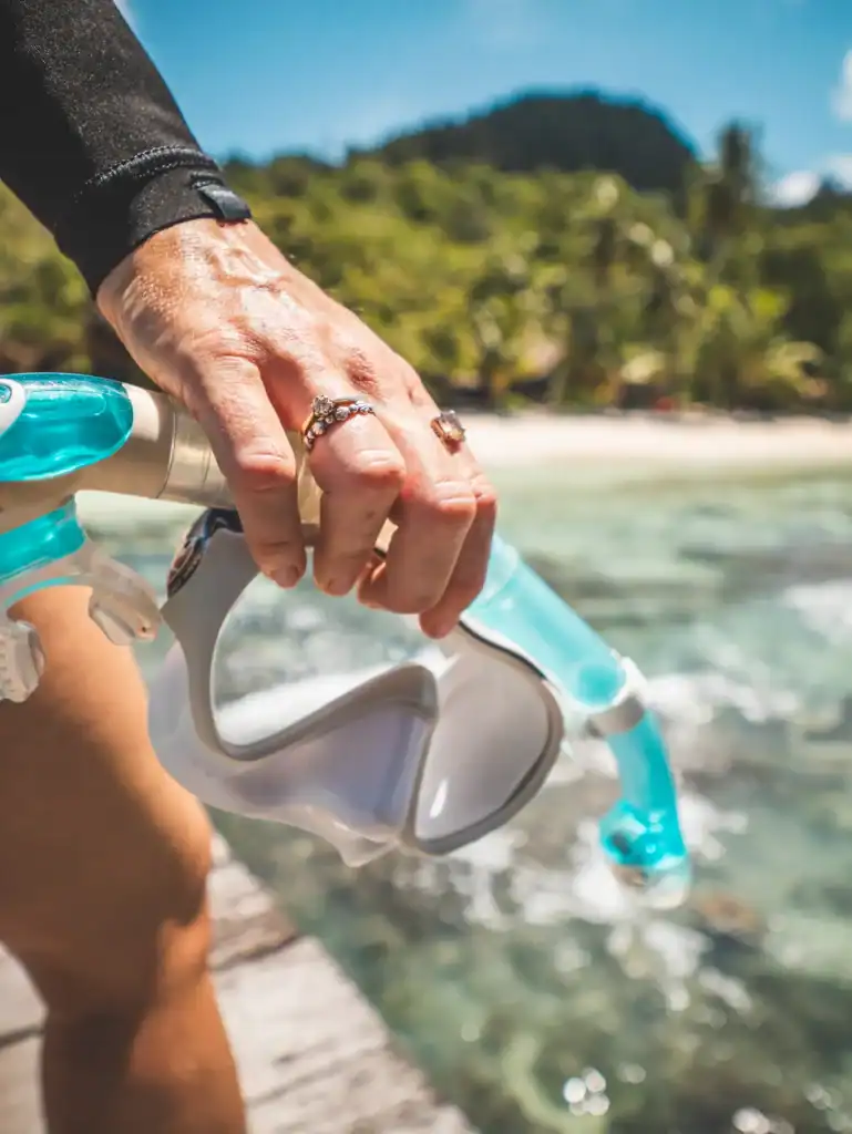 Closeup of snorkel mask being held before water entry, showing correct mask seal area