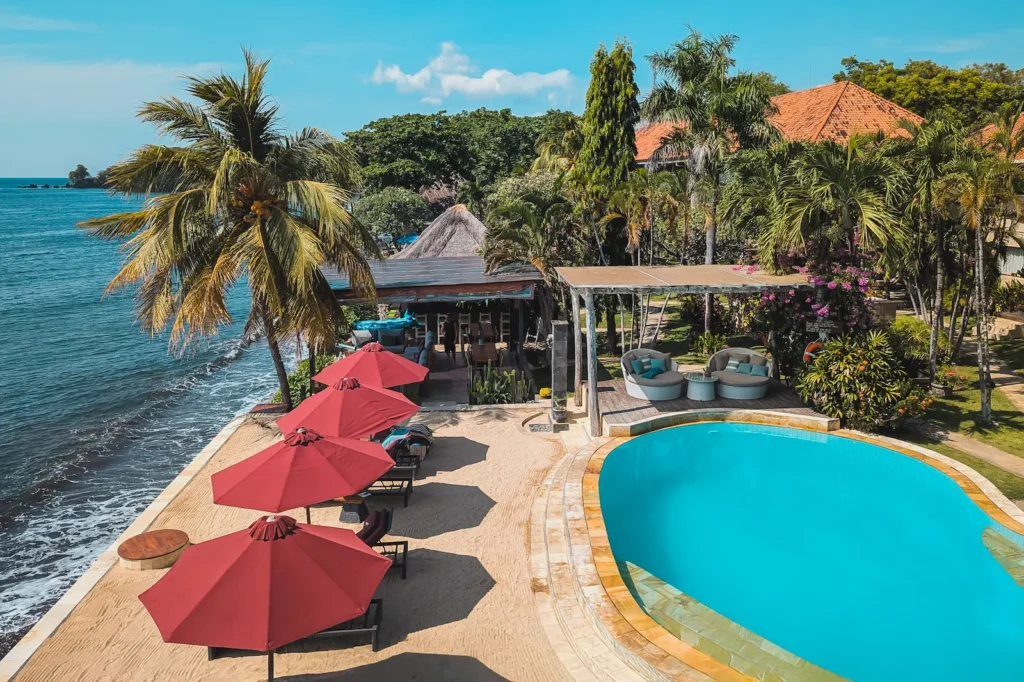 Oceanfront pool area at Tauch Terminal Resort overlooking the black sand beach of Tulamben.