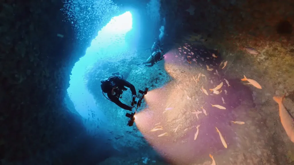 Scuba diver swim through cave South Lombok dive site